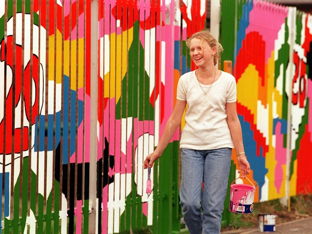 Teenagers from Fairfield Youth Centre painted a mural on the fence surrounding their building in August 1999. Pictured is Vicky Linton taking her turn with a paint pot and brush.