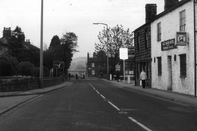 Main Street in Pool from the junction with Church Lane, and looking north-west. The junction of Pool Road and the A658 can be seen in the distance, centre. On the right is the Half Moon Hotel,and beyond it, a petrol station.