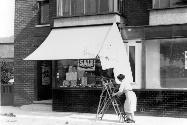 A view of Babywear shop on Selby Road pictured in August 1937. Shopkeeper can be seen to the front of shop. Shop on right is To Let.