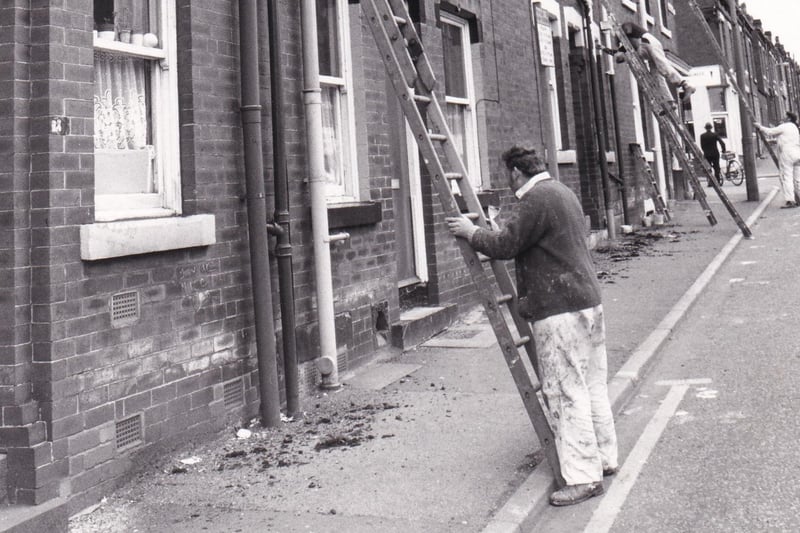 An army of painters gets to work on empty houses in June 1981.
