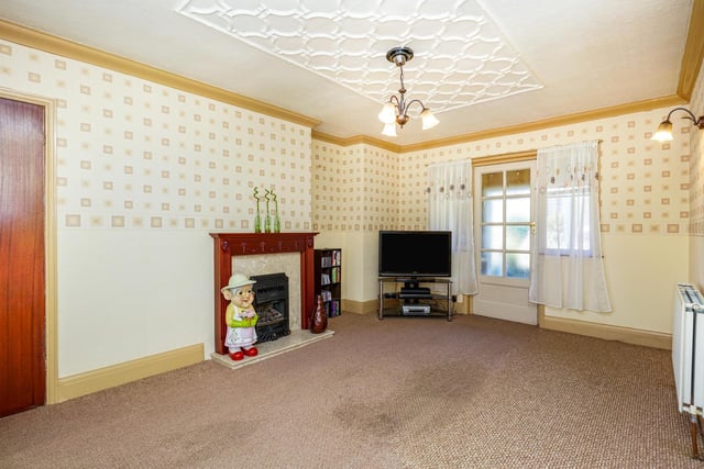 Also on the ground floor is a spacious living area with a bay window and a characterful fireplace.