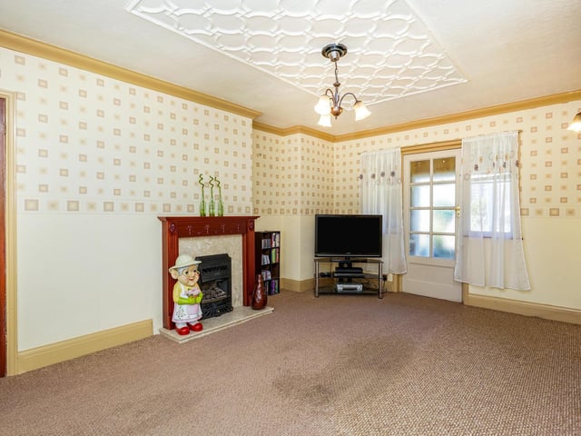 Also on the ground floor is a spacious living area with a bay window and a characterful fireplace.