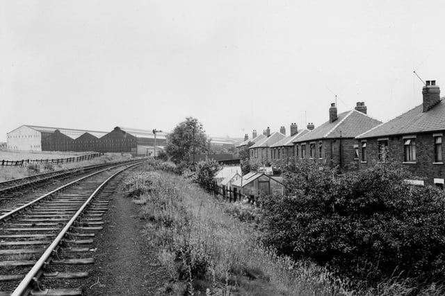 July 1956 and  a view west along the railway line towards Dunlop and Ranken stockyard on Whitehall Road. On right are houses and gardens of the Kirkdale Housing Estate.