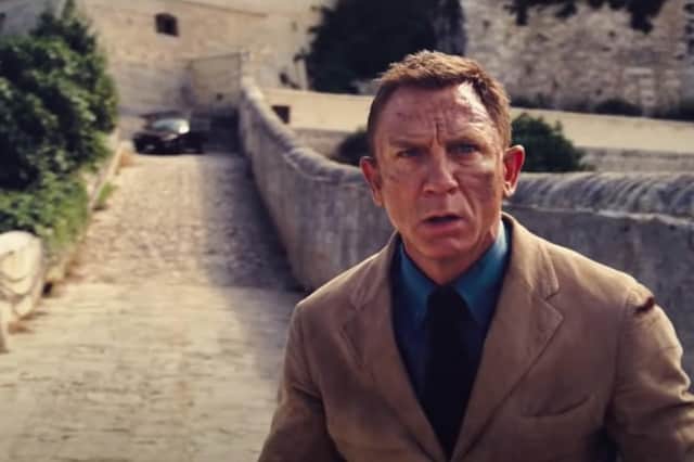The trailer begins with Bond in Italy, jumping out of the way of a speeding car at the top of an old viaduct