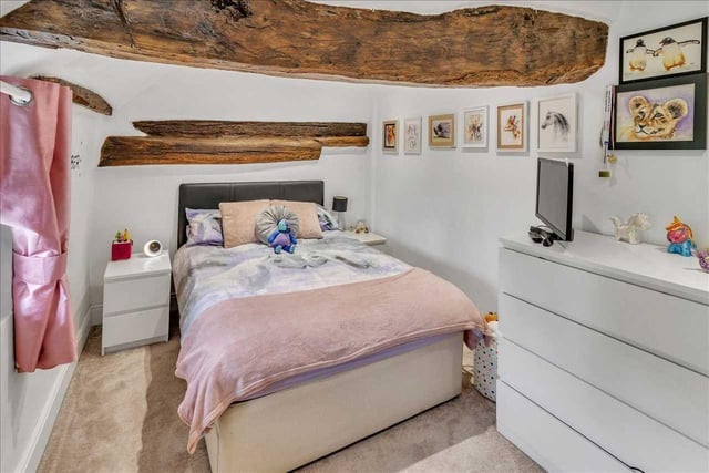 The spacious second bedroom also has exposed beam feature across the window and ceiling with period traditional entrance door.