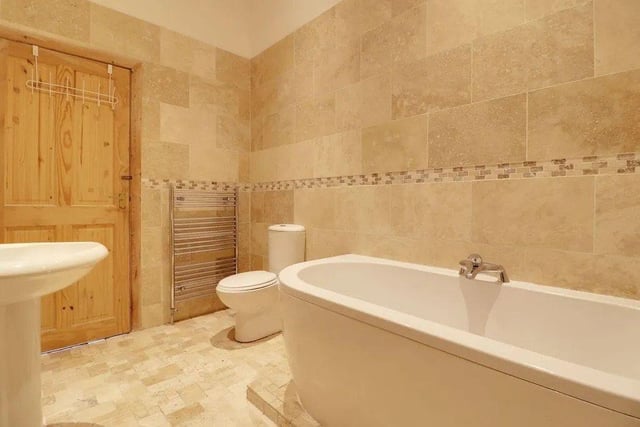 A spacious en-suite bathroom features a wet room style walk in shower, separate bath, wash hand basin and W.C.