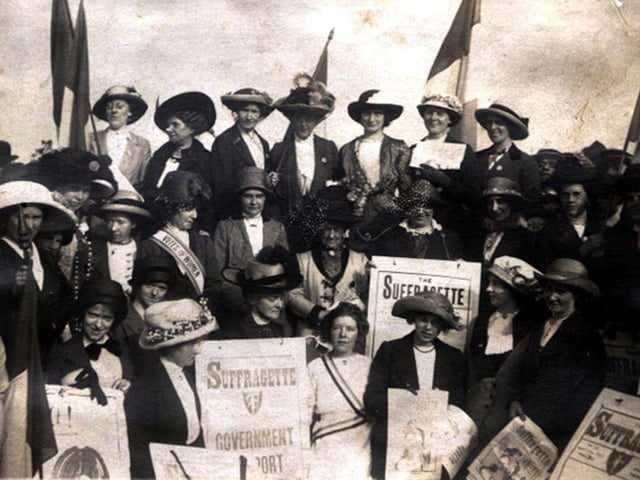 A group of women carrying placards and banners as they take part in the Women's Social & Political Union's Procession to Woodhouse Moor for a huge rally in July 1908. They began their march from Leeds Town Hall. Bands played on Woodhouse Moor where thousands of people, both men and women, had gathered to listen to the various speakers from the 10 platforms. One of the most famous of the suffragettes to address the crowds was Adela Pankhurst, daughter of Emmeline Pankhurst and sister of Sylvia and Christabel, all leaders of the British Suffrage movement.