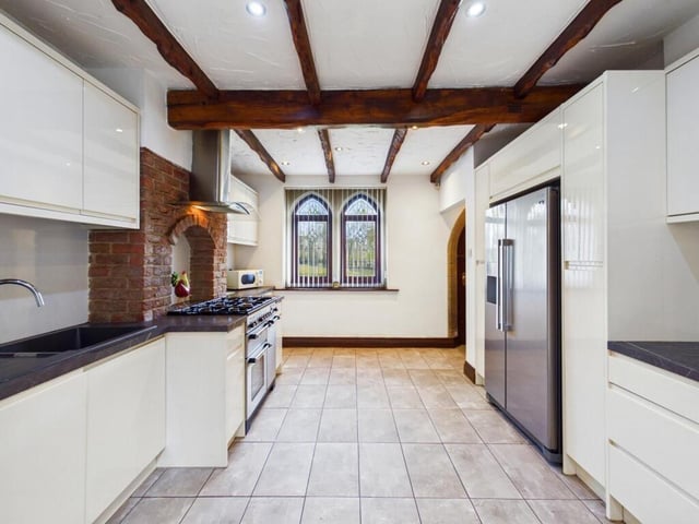 The kitchen features a range of high and low level kitchen base units with integrated appliances including an extractor hood and dishwasher.