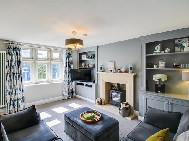 This cosy yet spacious room has a multi-fuel burning stove with limestone hearth and surround, a column central heating radiator and bespoke fitted shelving.