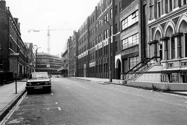 Park Place towards King Street, showing industrial buildings on either side. A car is parked by a parking meter on the left. A crane can be seen in the background where offices are under construction on King Street. Pictured in September 1980.