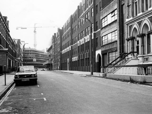 Park Place towards King Street, showing industrial buildings on either side. A car is parked by a parking meter on the left. A crane can be seen in the background where offices are under construction on King Street. Pictured in September 1980.