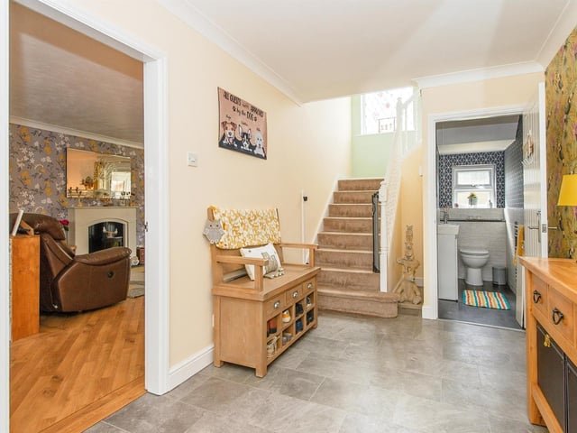 The front entrance hall with staircase up, leads to ground floor rooms, including a cloakroom.