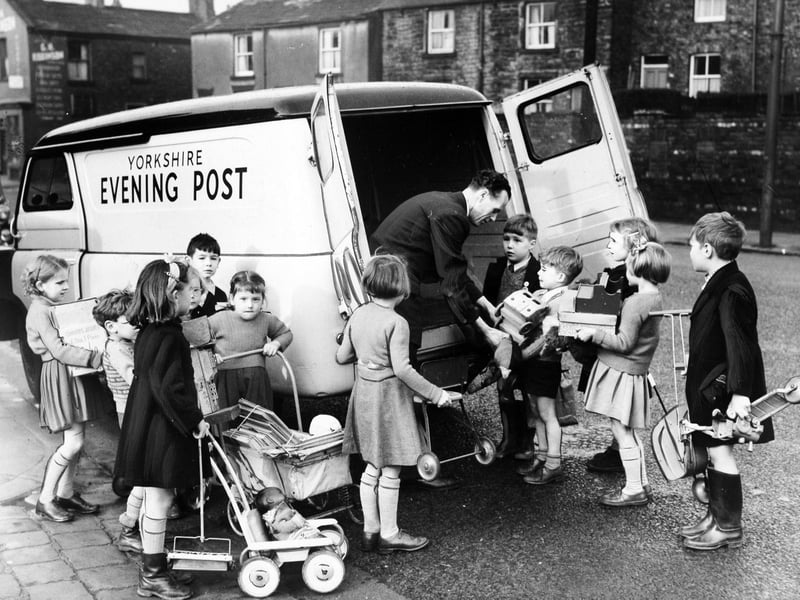 November 1954 and pupils from Lower Wortley Infant's School are seen handing toys to a Yorkshire Evening Post van driver which they had collected for the paper's Toy Appeal.