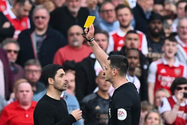 DEFIANT MESSAGE: From Arsenal boss Mikel Arteta, left, pictured being booked by referee Andrew Madley in Sunday's crushing 3-0 defeat against Brighton at the Emirates. Photo by GLYN KIRK/AFP via Getty Images.