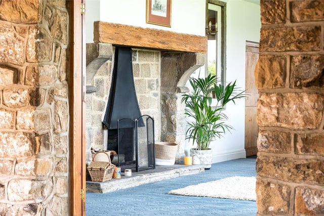 An impressive entrance hallway awaits which features a central stone fireplace.