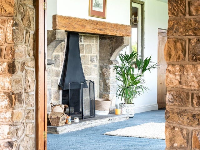 An impressive entrance hallway awaits which features a central stone fireplace.