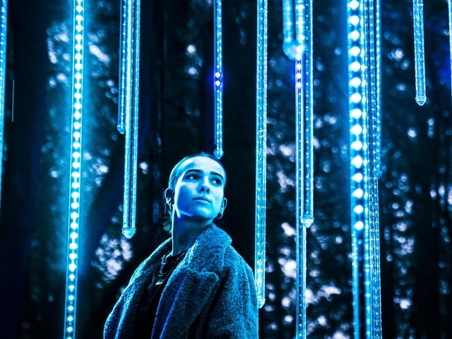 Poppy Wood wanders through one of the light installations.