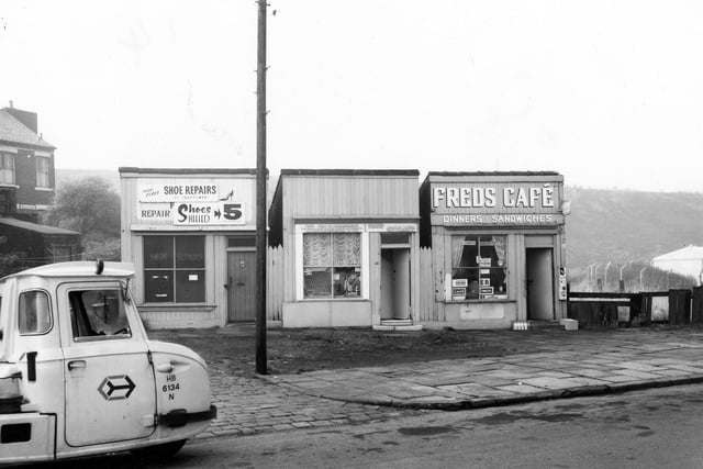 Three commericial properties on Cow Close Road pictured in October 1969. Number 43 is a cobblers, offering 'Shoes heeled in 5 minutes'. In the centre is Elizabeth hair stylist with an advert for Ladyset perms in the window. This is number 45. On the right is number 47, Fred's Cafe offering dinners and sandwiches. A crate of milk bottles can be seen to the left of the doorstep.