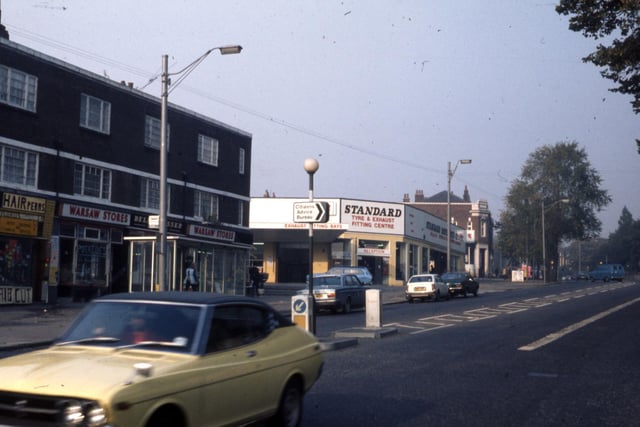 Chapeltown Road showing a hairdressers on the left hand side followed by Warsaw Stores delicatessen. After the junction with Mexborough Drive is Standard Tyre & Exhaust Fitting Centre.