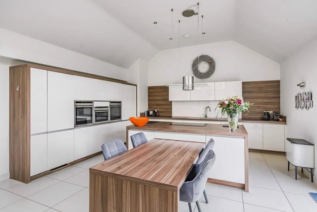 A central island unit incorporates an induction hob with additional storage units below, and there is a retractable dining table that can be extended out to sit more guests if required.