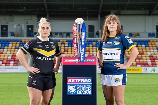 Rhinos captain Hanna Butcher, right, with York skipper Sinea Peach and the Betfred Women's Super League trophy at LNER Community Stadium, which will stage Sunday's final. Picture by Allan McKenzie/SWpix.com.