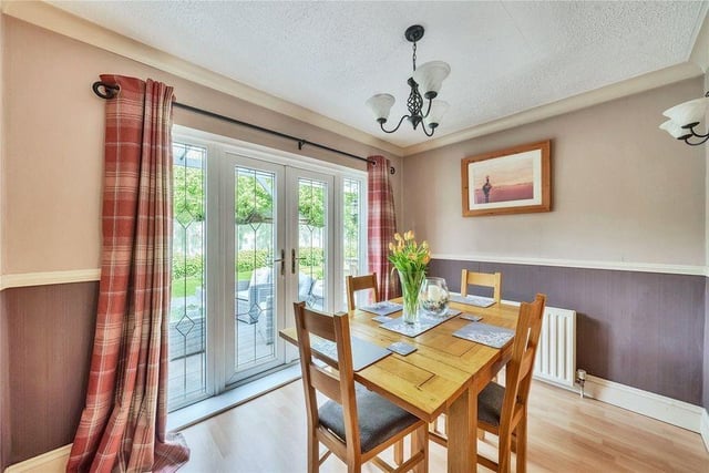 The stylish dining room features double-glazed patio doors that open onto the rear garden.