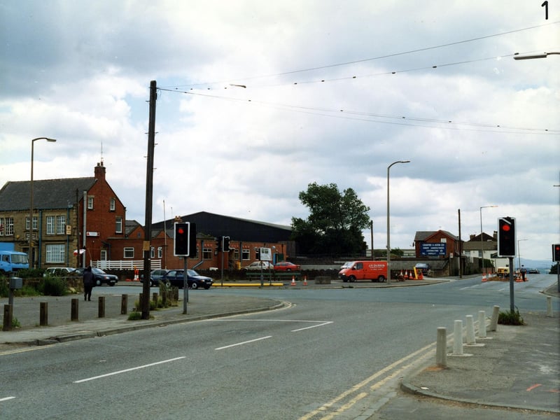 July 1990 and pictured is Bruntcliffe Lane looking onto the junction with Bruntcliffe Road to the left, Howden Clough Road ahead and Wakefield Road to the right. On the left is the Bruntcliffe Working Men's Club; behind this, are the works of Crabtree & Astin Ltd, joinery manufacturers. The white building on the right is the Shoulder of Mutton Inn.