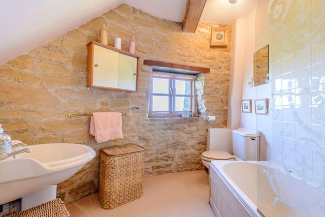 A charming bathroom with a window, includes both bath and shower.