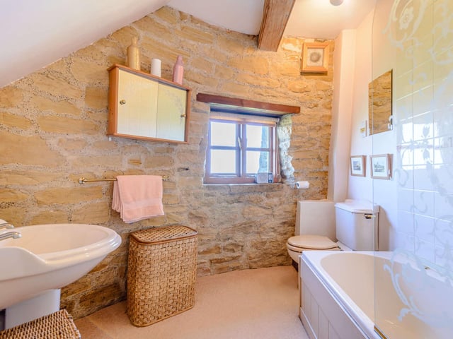 A charming bathroom with a window, includes both bath and shower.