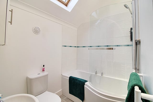 A smart family bathroom benefits from a panelled shower bath with a Triton electric shower, a pedestal wash hand basin and a low level toilet.
