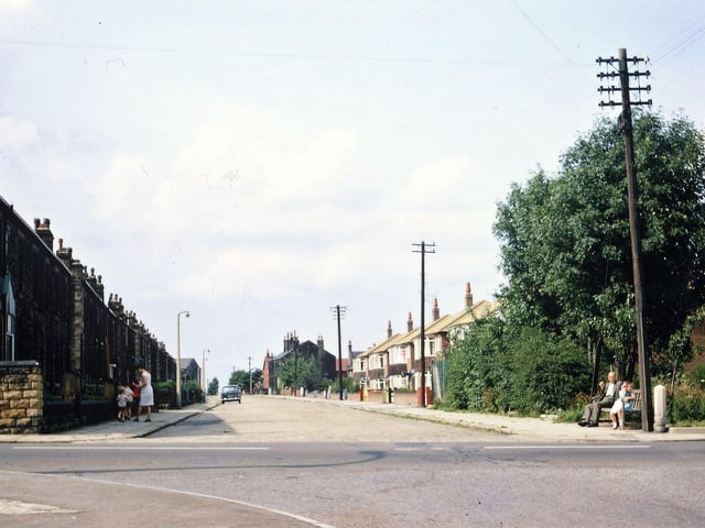 Looking down Springfield Lane from the junction with Victoria Road. The Shell filling station at the right hand corner has just been built but the corner seat is still there, the pavement is still slabs and the road sandstone setts. Only one car is parked on the street, Springfield Mills is just visible and the first two houses (one in Springfield Lane and one in Springfield Road) on the left have not yet been demolished to improve visibility.