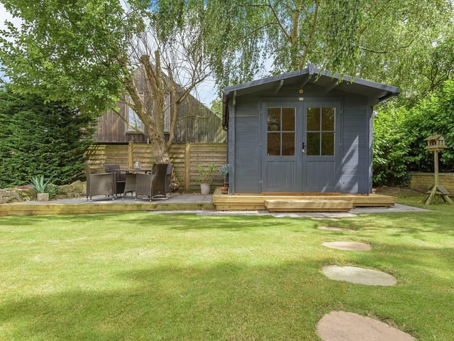 A summer house with outdoor seating area in the gardens.