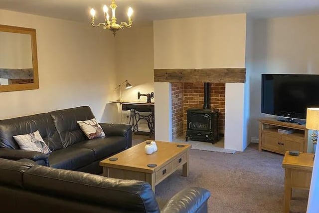 The living room has two large settees and oak furniture.