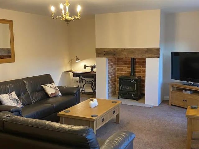 The living room has two large settees and oak furniture.