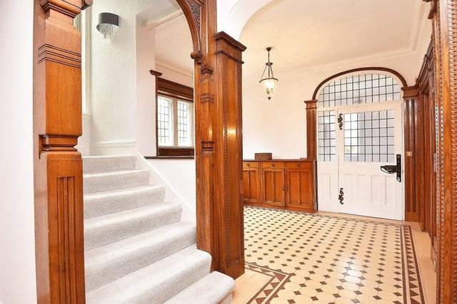 Oak wood panelling to the walls, and a mosaic tiled floor feature within the entrance hallway.