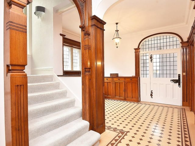 Oak wood panelling to the walls, and a mosaic tiled floor feature within the entrance hallway.