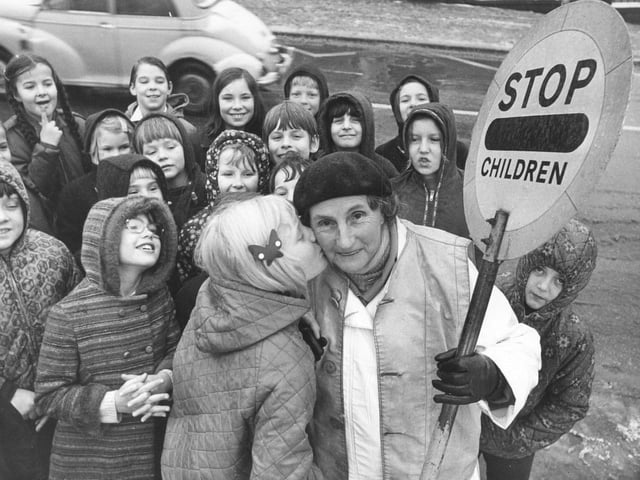 Mary Thrippleton who had completed 20 years as a lollipop lady outside New Park Primary Schoo is given a kiss by Sally Bowers in December 1973.