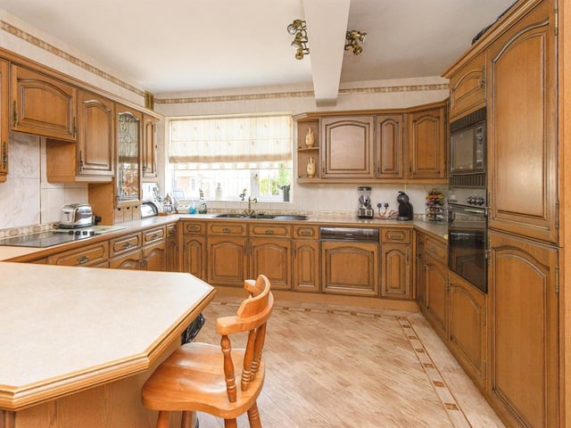 The fitted timber dining kitchen has an electric oven and hob with integrated appliances that include a fridge freezer and a dishwasher.