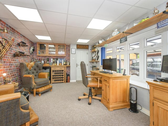 A feature brick wall, a solid oak fitted bar, and glass wall units form part of this office, that has outdoor access.