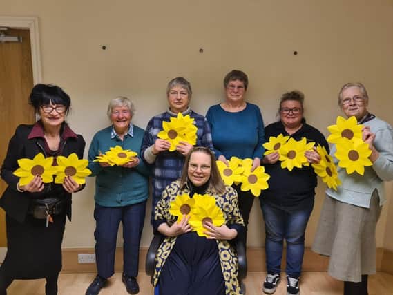 1)	Rosemary (seated) and Helen (second from the right) with the group who spent the afternoon cutting and sticking hundreds of sunflowers 