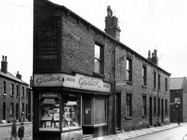 Two boys stand next to a grocers and confectioners on Main Road in August 1966.  The names C. & A. Garlick are over the door. A painted wall sign above the window bears the name C. Briggs, the proprietor of a tobacconists here between the 1910s and the late 1940s.