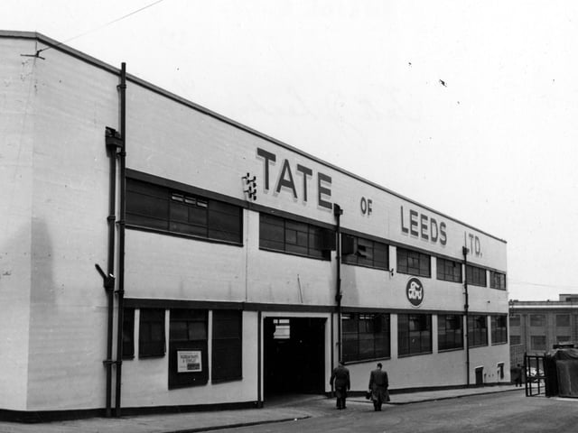 Two men walk down Trafalgar Street towards Bridge Street in May 1955. The gas offices on Bridge Street can be seen to the right of the photograph. Ford Motor dealers Tate of Leeds Ltd., had other premises on New York Road which backed on to Trafalgar Street just out of view to the right.