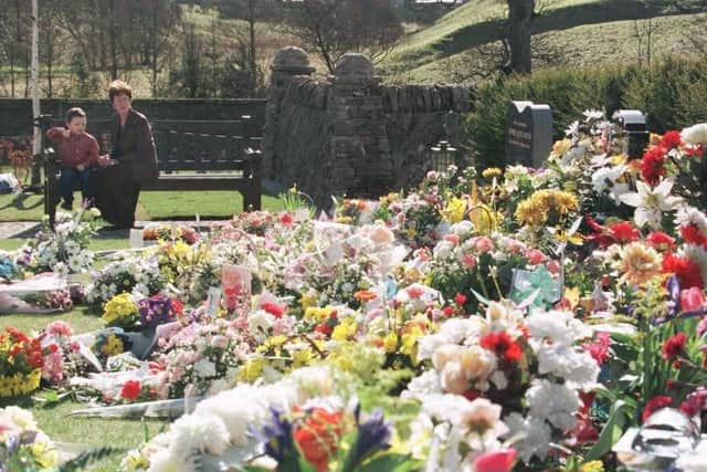 Three-year-old Connor Clydesdale sits with mother Irene in the Dunblane Memorial Garden, which opened around the second anniversary of the Dunblane shooting in which 16 children and a teacher lost thier lives. Photo by Chris Bacon/PA.