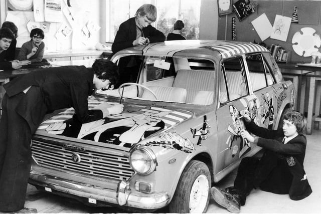 Art at Norton Comprehensive School took taken on a new meaning for  pupils Christopher Atkinson, Paul Wood and Stewart Frank in March 1981. They were customising an old Austin 1100 woth comic strip characters before the car goes on show in the school courtyard.