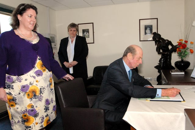 The Duke signs the visitors book watched by Dr. Angela Nall, left, the general manager of the Pathfinders Neurological Care Centre.