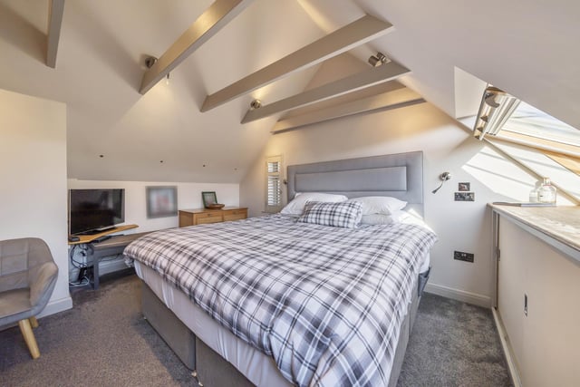 A turned bespoke staircase provides access to the first floor where there is a charming double bedroom with sloping ceilings, beams and eaves storage, with an en-suite shower.