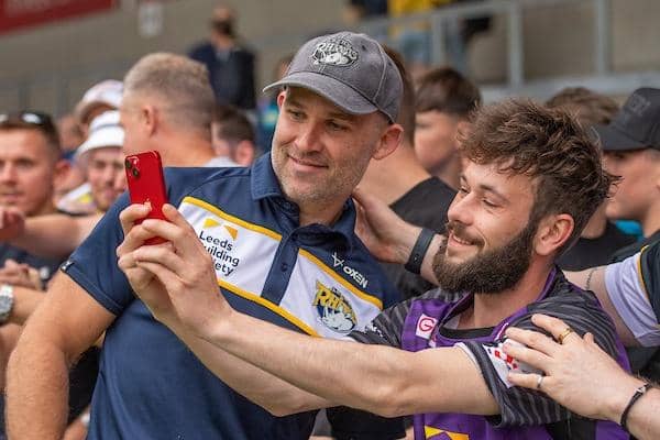 Rhinos coach Rohan Smith poses for a picture with a fan after Leeds' win at Salford. Picture by Olly Hassell/SWpix.com.
