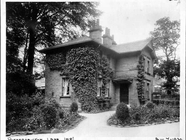 Harehills Lane improvements in August 1930. Photograph marked 'Dwelling house concerned with highway improvement'. Brick built detached house, with formal flower beds. One of the lodge houses for Potternewton Park.