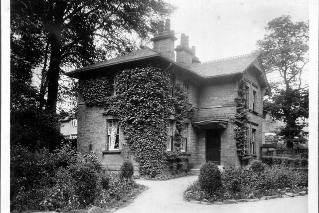Harehills Lane improvements in August 1930. Photograph marked 'Dwelling house concerned with highway improvement'. Brick built detached house, with formal flower beds. One of the lodge houses for Potternewton Park.