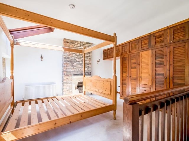 One of the bedrooms with feature open brickwork and fitted storage.